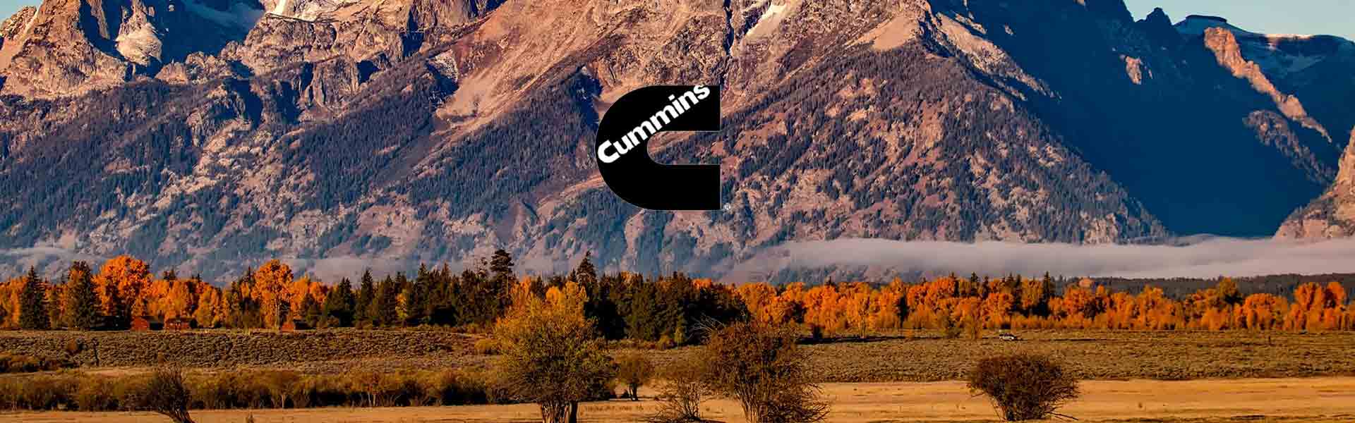 Mountain background with fall colors and low clouds with Cummins Logo
