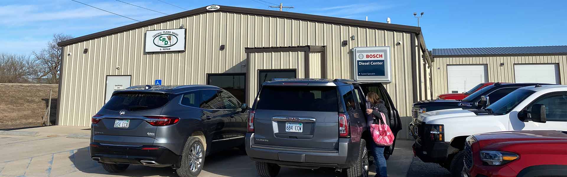 Outside shot of CDP building showing small part of parking lot with many vehicles
